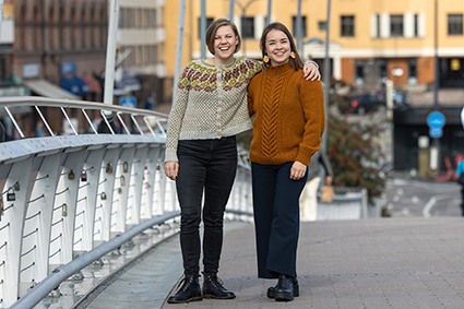Naiset ruskean sävyissä olevissa neuleissa.