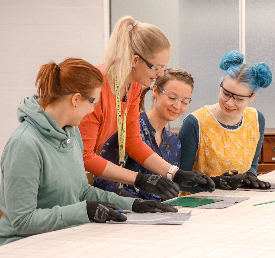 Käsityö- ja muotoilukoulu Näpsän aikuiset oppiskelijat tekevät lasitöitä opettajansa johdolla.
