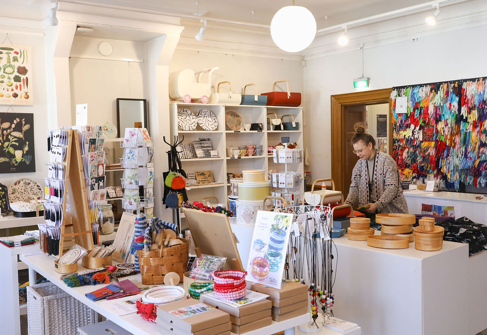 Taito Shop Turun myymälävastaava Paula Vanne asettelee tuotteita myymälässä