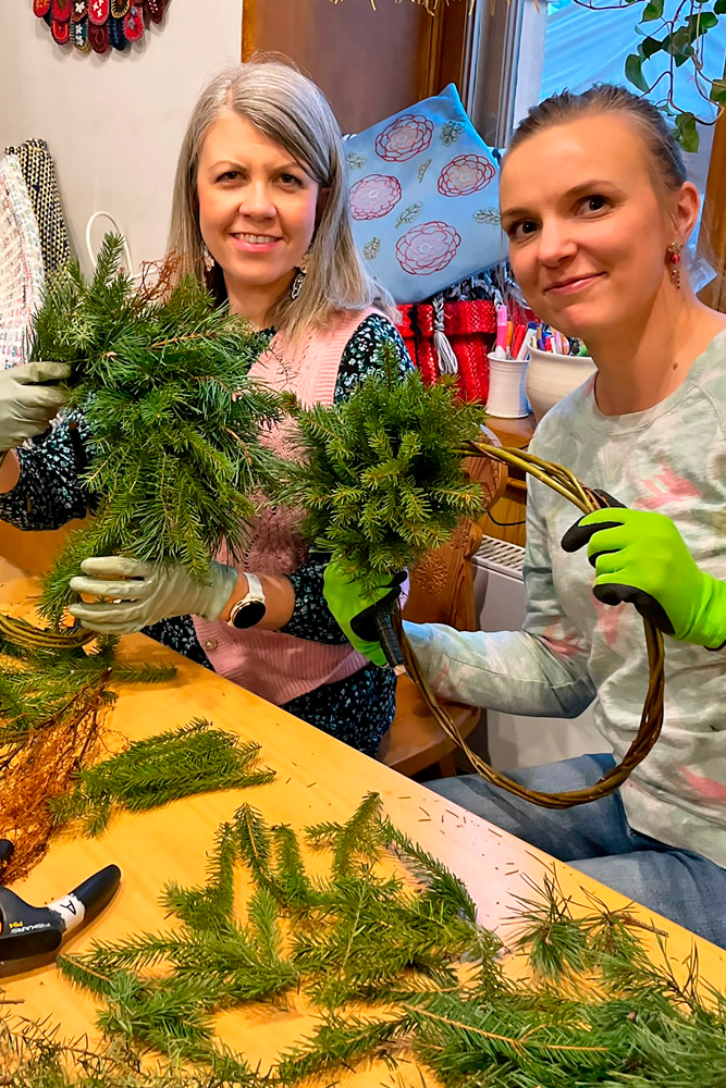Havukranssikurssilaiset poseeraavat innokkaana keskeneräiset kranssit kädessään.