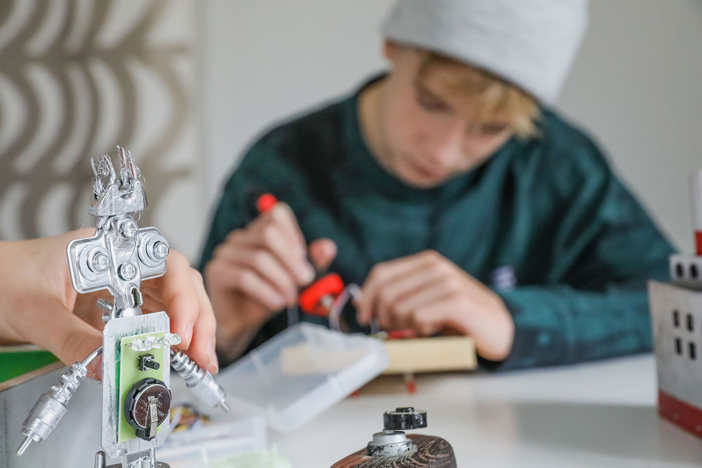 Nuoria rakentamassa robottia.