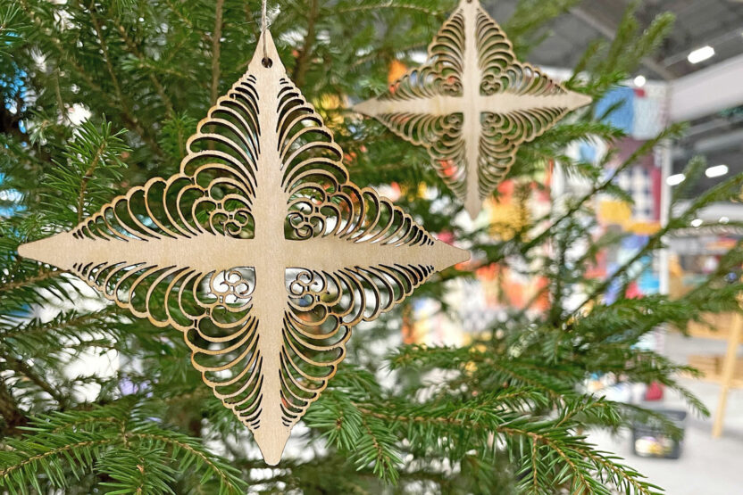 Puinen tuomaantähti-koriste ripustettuna joulukuuseen.