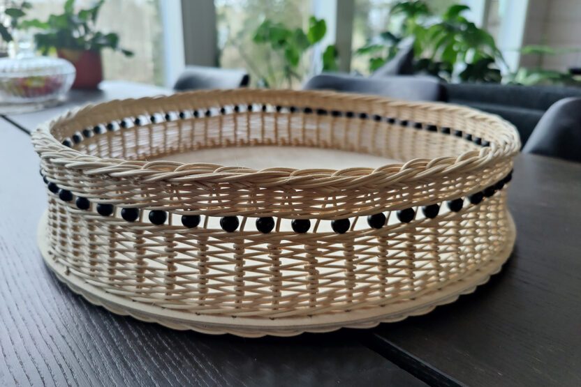 Rottinkinen tarjoilukori pöydällä.