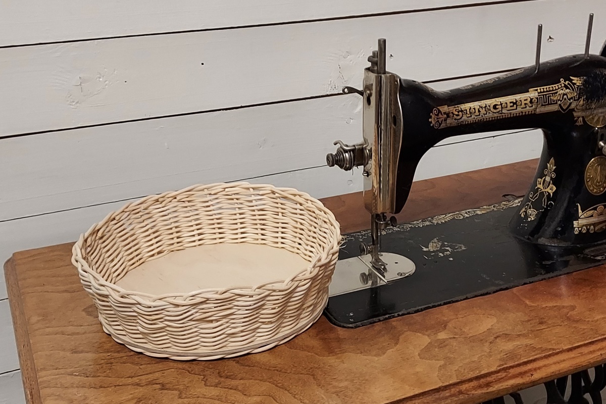 rottinkinen leipäkori vanhan ompelukoneen vieressä